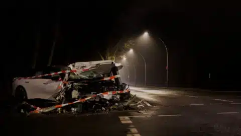 A wrecked car on a dimly lit street at night, illustrating the aftermath of a crash and the need for legal help.